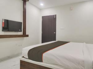 a bedroom with a bed and a flat screen tv at Collection O HOTEL RB GRAND @ KOMPALLY in Hyderabad
