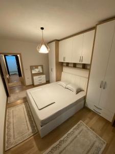 a bedroom with a large white bed and a window at Violin 2 bedroom Apartment downtown Prizren in Prizren
