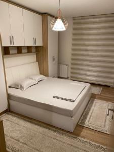 a bedroom with a large white bed and a window at Violin 2 bedroom Apartment downtown Prizren in Prizren