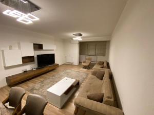 a living room with a couch and a flat screen tv at Violin 2 bedroom Apartment downtown Prizren in Prizren