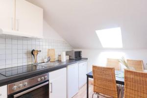 a kitchen with a sink and a table with chairs at - 3-Bedroom Apartment Luxury: Central & Spacious in Duisburg & Big TV and Kitchen - in Duisburg