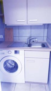 eine Küche mit einer Waschmaschine und einem Waschbecken in der Unterkunft 2 Zimmerwohnung in Mönchengladbach