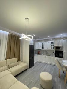 ein Wohnzimmer mit einem Sofa und einer Küche in der Unterkunft Dreams Apartment in Korçë