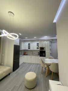 eine Küche mit weißen Schränken sowie einem Tisch und Stühlen in der Unterkunft Dreams Apartment in Korçë