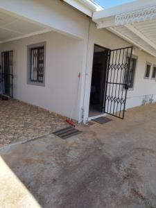 an open door of a white building with a gate at 4 Centenary Road Ixopo in Ixopo