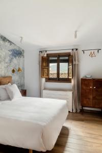 a bedroom with a white bed and a window at Apartamentos turísticos EL PATIO DEL NOGAL in Guadalupe