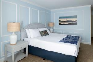 a blue bedroom with a bed and a table with a lamp at Coventry Motor Inn in San Francisco