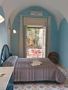 1 dormitorio con 1 cama, mesa y sillas en Dimora di Enea - Gaeta Medievale en Gaeta