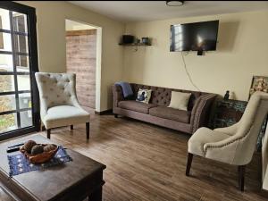 a living room with a couch and two chairs at Loft Candelaria Antigua in Antigua Guatemala