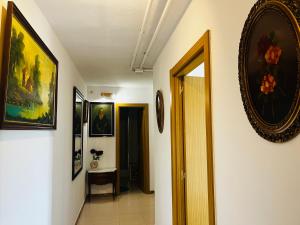 um corredor com pinturas nas paredes e uma porta em Art House em Alicante