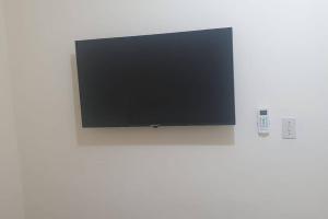 a flat screen tv hanging on a white wall at Refugio Urbano, Res. Uvas Sur in Tegucigalpa