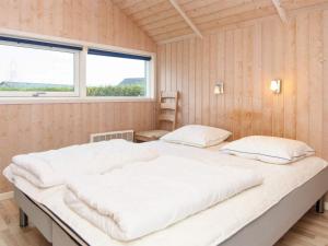 a large bed in a room with two windows at Holiday home Sydals XCII in Neder Lysabild