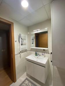 a white bathroom with a sink and a mirror at Sweety home in Esenyurt