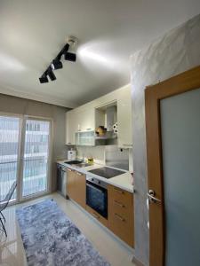 cocina con armarios blancos y ventilador de techo en Sweety home, en Esenyurt
