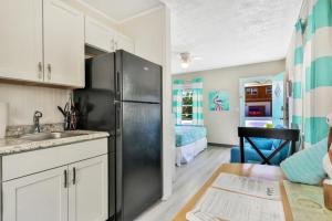 a kitchen with a black refrigerator in a room at Pelican Beach Studio 7 in Clearwater Beach