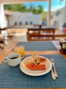 a plate of food and a cup of coffee on a table at POUSADA RECANTO DAS VERTENTES in Capitólio