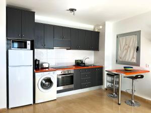 a kitchen with a white refrigerator and a washer at Casa La Olas in Morro del Jable +10 photos