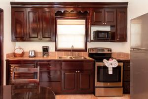 a kitchen with wooden cabinets and a stainless steel refrigerator at X'tan Ha- The Waterfront in San Pedro