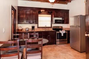 a kitchen with a table and a stainless steel refrigerator at X'tan Ha- The Waterfront in San Pedro