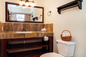 a bathroom with a sink and a mirror and a toilet at X'tan Ha- The Waterfront in San Pedro