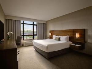 Great Blue Heron Hotel في بورت بيري: غرفة فندقية بسرير كبير ونافذة