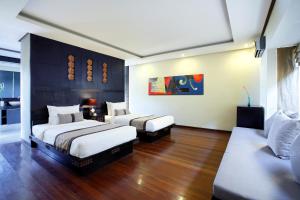 a hotel room with two beds and a couch at Lalasa Villas Canggu in Canggu