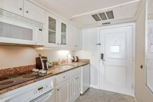 a kitchen with white cabinets and a white door at Marco Beach Ocean Resort 1102 in Marco Island