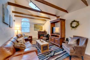 a living room with a leather couch and chairs at Rustic Log Cabin with Studio about 5 Mi to Pikes Peak! in Green Mountain Falls