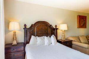 a bedroom with a bed with two lamps and a couch at The Grand #2611 in Destin