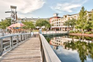 a wooden walkway next to a river with buildings at The Grand #2611 in Destin