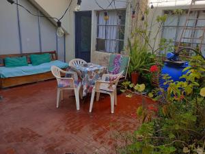 patio ze stołem, krzesłami i kanapą w obiekcie Chandra Alojamiento en casa de familia w mieście Gualeguaychú