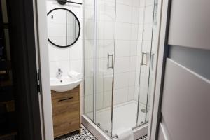 een badkamer met een douche en een wastafel bij CracWoW K8 No.10 Apartment in Krakau