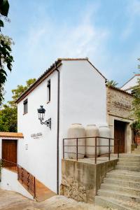 un edificio blanco con una escalera que conduce a él en Apartamentos turísticos EL PATIO DEL NOGAL en Guadalupe