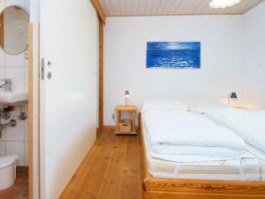 ein weißes Schlafzimmer mit einem Bett und einem Waschbecken in der Unterkunft Holiday home Sydals XXXI in Neder Lysabild