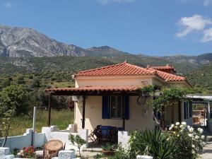 a small house with a mountain in the background at A CASA D'IRENE in Votsalákia