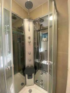a bathroom with a shower with a toilet and a glass shower at Lovely 1 bedroom flat in Chigwell