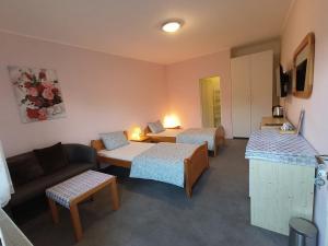 a hotel room with two beds and a couch at Cozy Room with garden in Bratislava in Bratislava