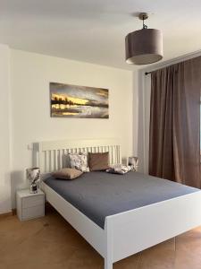 una camera con un letto bianco e una coperta blu di Lovely sunny Apartment ad Adeje