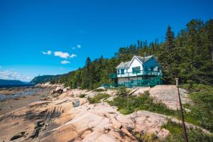 uma casa na costa de uma praia rochosa em Centre de Vacances 5 Étoiles Family Resort em Sacré-Coeur-Saguenay