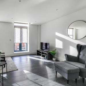 a living room with a couch and a mirror at Exceptionally Spacious Central Canterbury Home in Canterbury