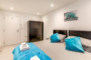 um quarto com 2 camas e almofadas azuis em Exceptionally Spacious Central Canterbury Home em Canterbury