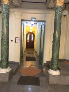 a hallway in a building with green columns at Kecskeméti Rooms in Budapest