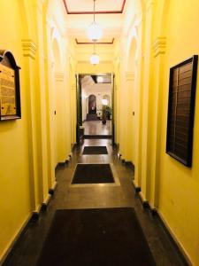 a hallway of a building with yellow walls and rugs at Kecskeméti Rooms in Budapest