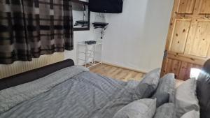 un dormitorio con una cama en una habitación en Comfortable 2 bedroom house with free parking and great transport links, en Dagenham