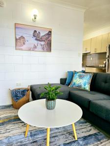 una sala de estar con un sofá y una mesa en Bakers Sea Breeze Escape, en North Ward