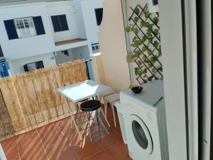 een wasruimte met een wasmachine en een tafel bij Apartamento de 3 habitaciones, zona muy tranquila a unos minutos de la playa in Mazagón