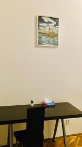 uma mesa com uma cadeira e uma foto na parede em Private room in Prague Centre em Praga