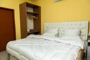 a large white bed in a bedroom with yellow walls at Planet Golf - foxdale in Foxdale Estates