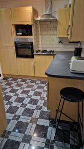 cocina con suelo a cuadros y encimera en Comfortable 2 bedroom house with free parking and great transport links, en Dagenham 5 fotos más