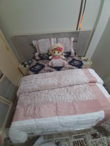 a small bed with a teddy bear sitting on it at Erki Guest House in Abu Simbel